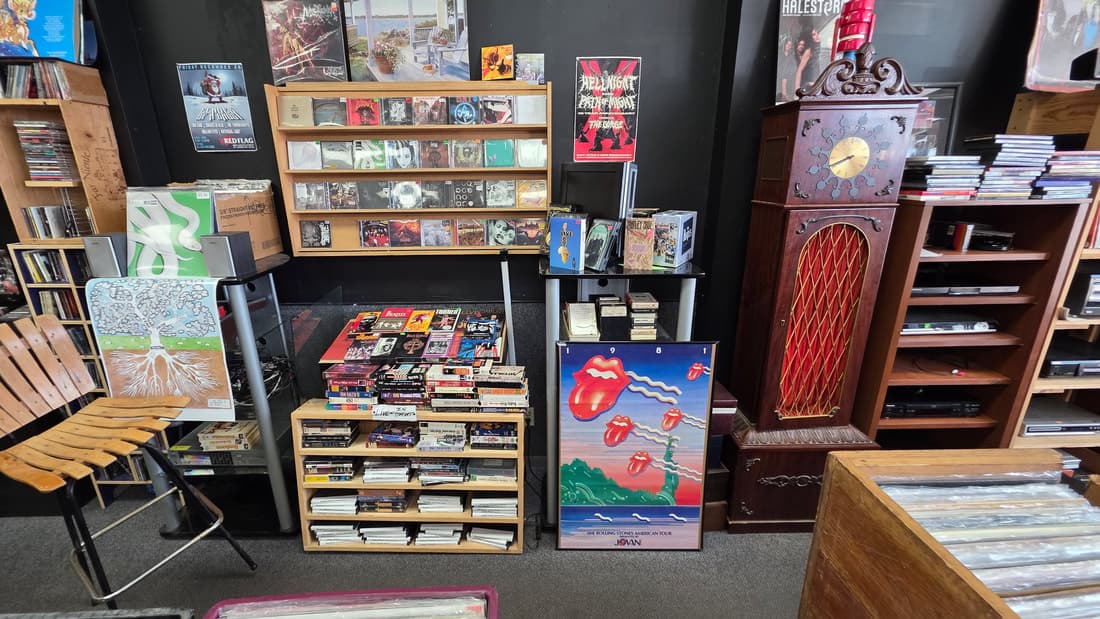 Wider view of the cassette and 8-track corner under the Rolling Stones tour poster with the grandfather clock