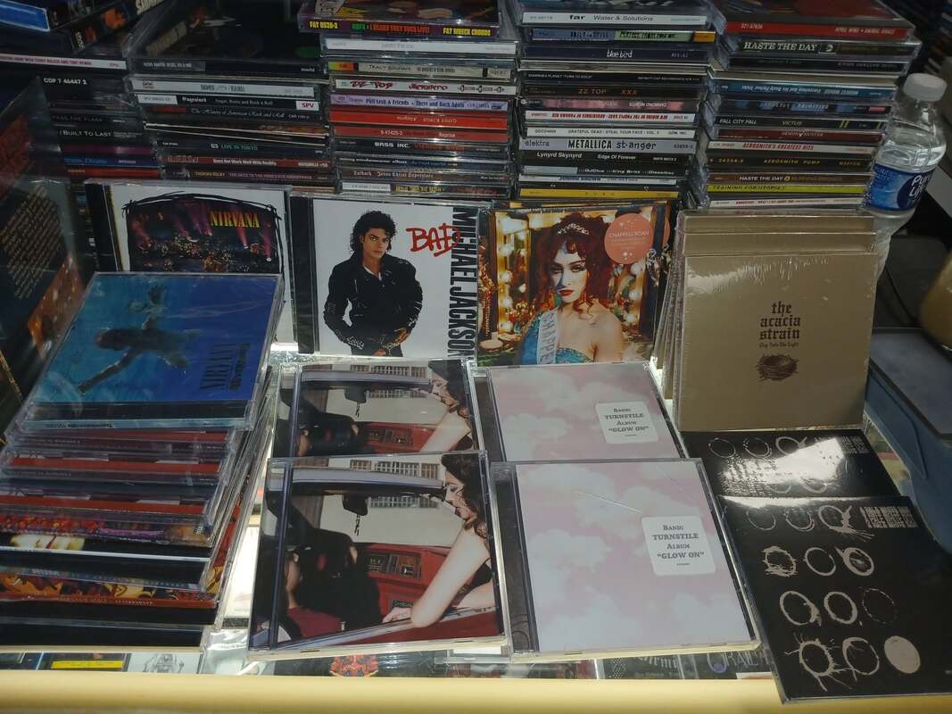 Counter display of new and recent CDs including Nirvana, Michael Jackson, Chappell Roan and Turnstile