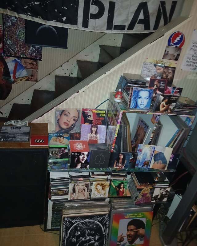 CD and vinyl display racks under the staircase in the Media Cavern building, banner overhead