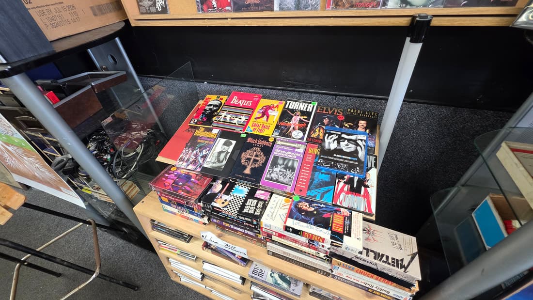 Glass case of music books and magazines covering the Beatles, Elvis and Metallica