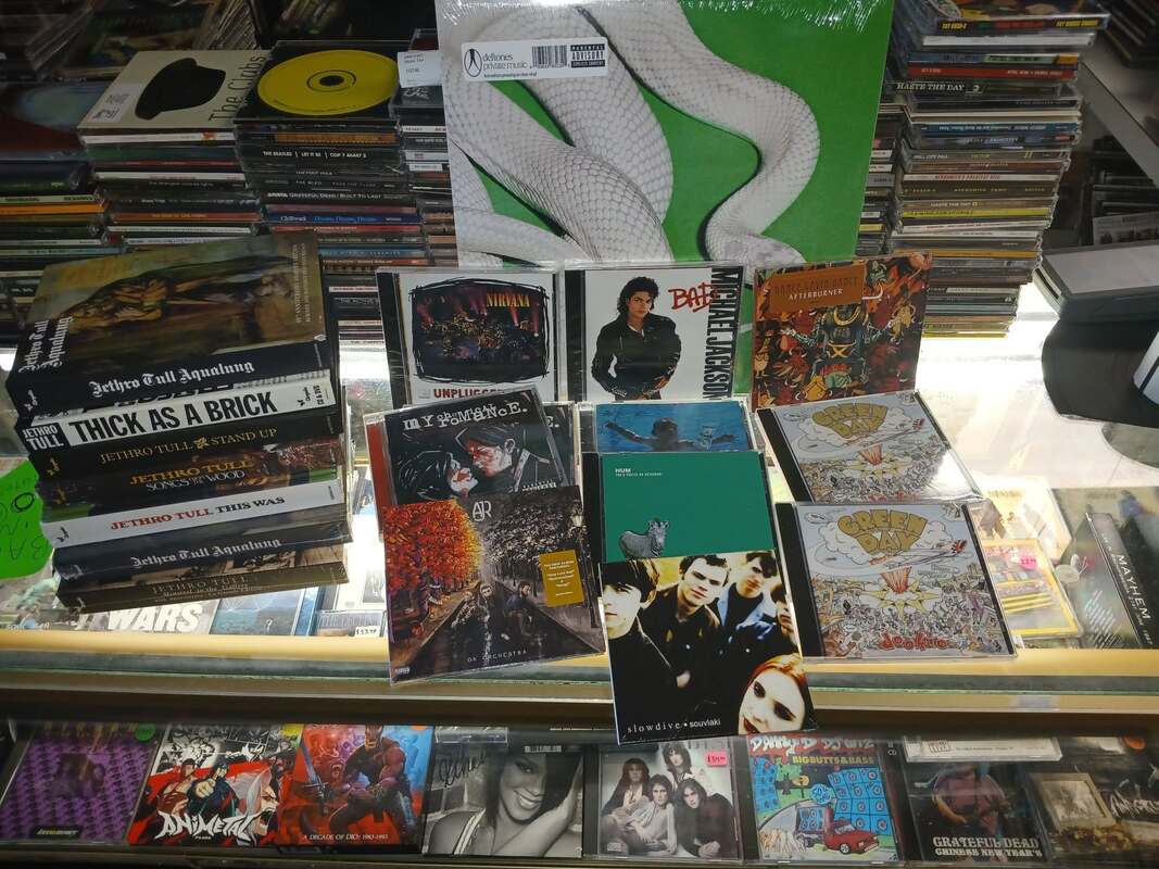 New-arrivals display on the glass counter with a sealed Deftones LP, Nirvana Unplugged, Michael Jackson Bad and Jethro Tull reissues