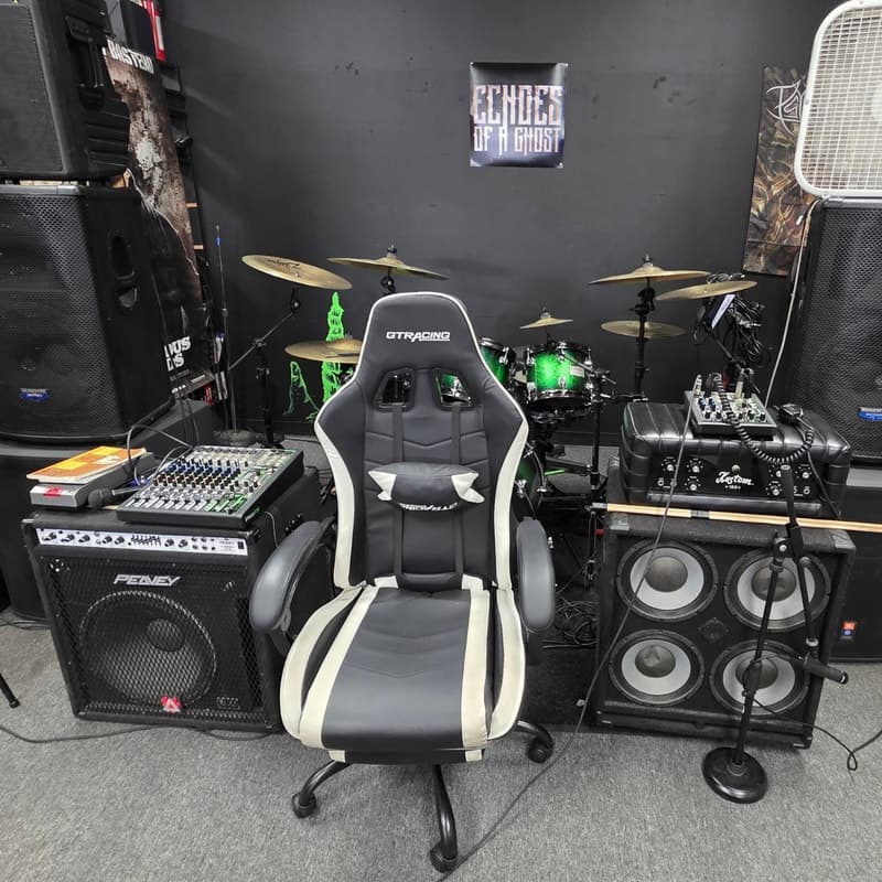 In-store stage corner with drum kit, PA speakers, mixer and an Echoes of a Ghost banner on the black wall