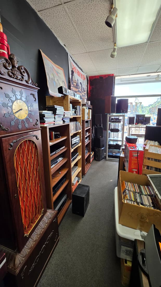 Aisle looking toward the front window past the grandfather clock, stereo components and an 8-track box