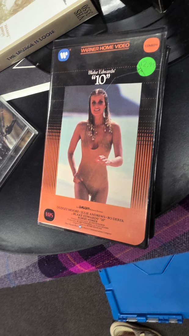 An ex-rental VHS of Blake Edwards 10, swimsuit cover art, lying on a record sleeve