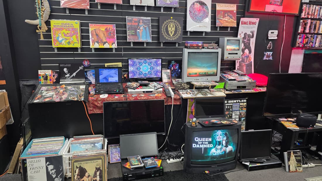 Slatwall of vinyl and CRT televisions, effectively the same frame as the wall-of-entertainment shot