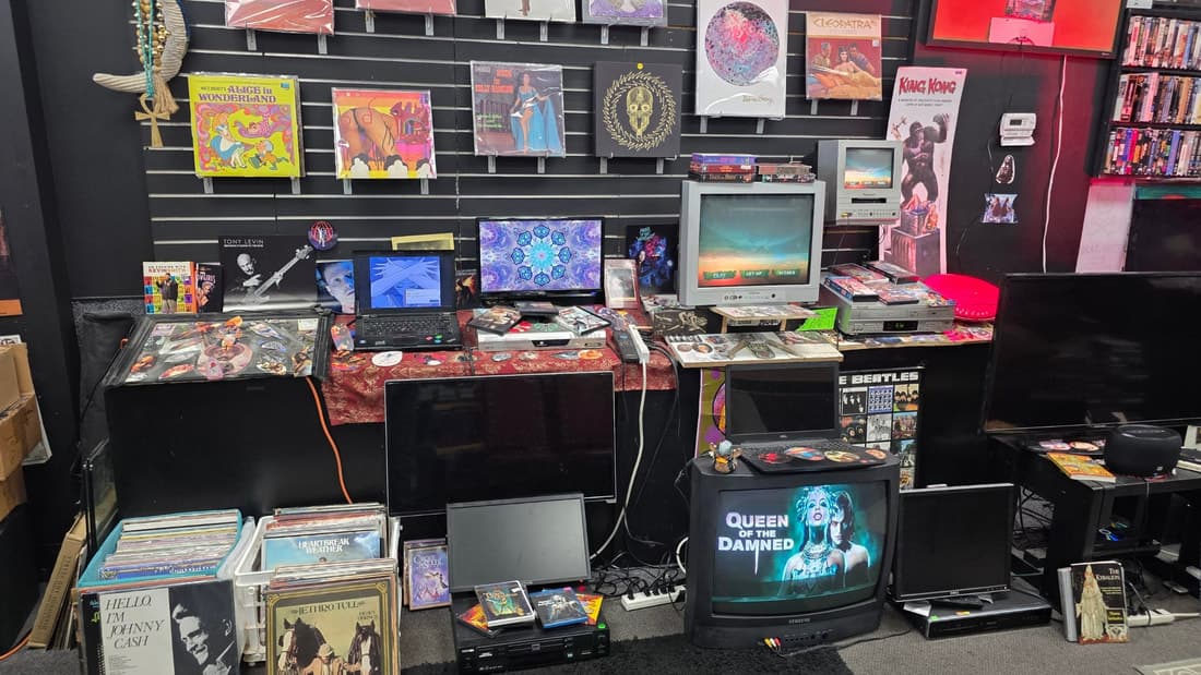 Slatwall of vinyl LPs and CRT televisions, one playing a film, with a King Kong poster