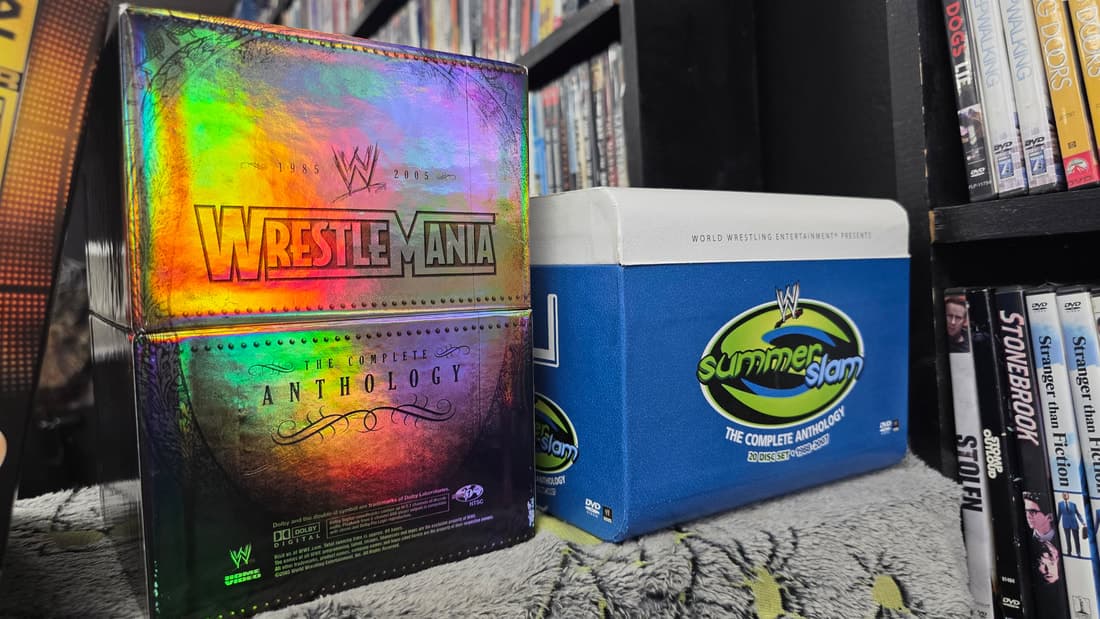 WrestleMania and SummerSlam anthology box sets in close-up against the DVD shelf